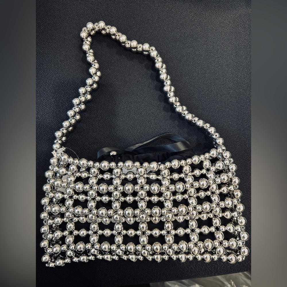 Silver Beaded bag with black drawstring insert. NWT